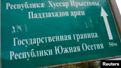 Грузиядан бөлінген Оңтүстік Осетия шекарасындағы көрсеткіш жазу.